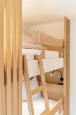 a room with a bunk bed with a ladder at VANEA - Alp Relax Guesthouse in Chienes