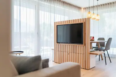 a living room with a tv and a table with chairs at VANEA - Alp Relax Guesthouse in Chienes