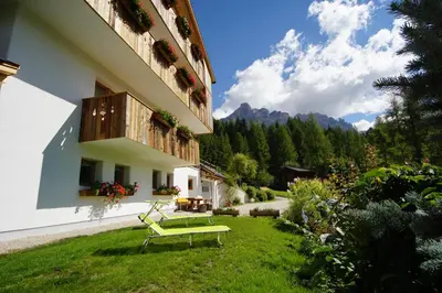 a green bench in a yard next to a building at Cresta in San Cassiano