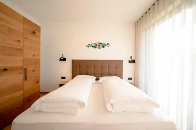 two beds in a bedroom with white walls and a window at Garden Lodge in Gargazzone