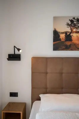 a bedroom with a bed and a picture on the wall at Garden Lodge in Gargazzone