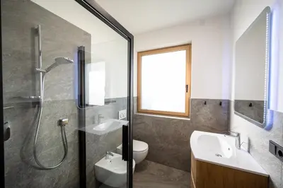 a bathroom with a shower and a toilet and a sink at Garden Lodge in Gargazzone