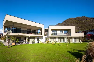 a large white house with a green yard at Garden Lodge in Gargazzone