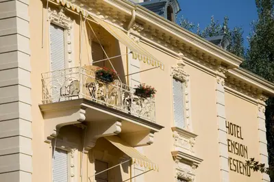 a building with a balcony with flowers on it at Hotel Villa Westend in Merano