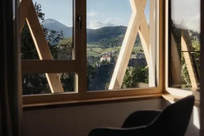 a room with a chair and a large window at Plattnerhof Viums in Naz-Sciaves