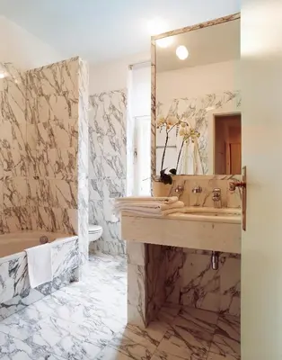 a bathroom with a sink and a tub and a mirror at Parkhotel Laurin in Bolzano