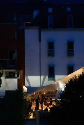 a building with people walking in front of it at night at Hotel Greif, a Member of Design Hotels in Bolzano