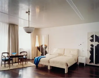 a bedroom with a bed and a table and chairs at Hotel Greif, a Member of Design Hotels in Bolzano