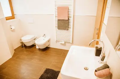 a bathroom with a tub and a toilet and a sink at Lü de Terza in San Vigilio Di Marebbe