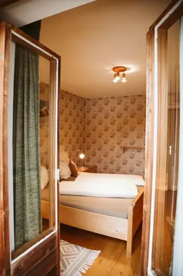 a small bedroom with a bed and a window at Lü de Terza in San Vigilio Di Marebbe