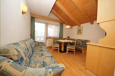 a living room with a couch and a table at Ciasa Wallis in Badia
