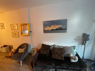 a bedroom with a bed and a chair in a room at Mazzin Raggio di Sole in Campestrin
