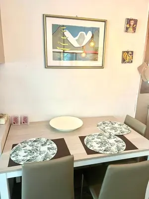 a dining room table with chairs and a picture on the wall at Mazzin Raggio di Sole in Campestrin