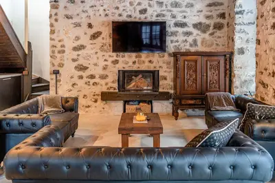 a living room with leather furniture and a fireplace at Villa Molin Del Faure in Alleghe