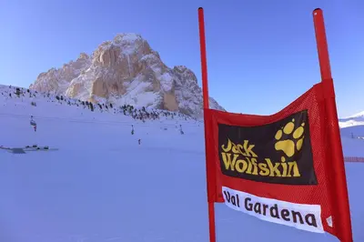 a sign in the snow with a mountain in the background at Residence Villa al Sole in Selva di Val Gardena