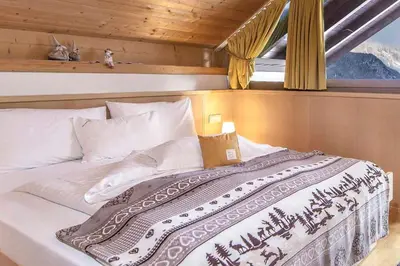 a bed in a room with a window at Residence Villa al Sole in Selva di Val Gardena
