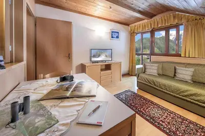 a living room with a couch and a table at Residence Villa al Sole in Selva di Val Gardena
