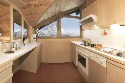 a kitchen with a view of a snow covered mountain at Residence Villa al Sole in Selva di Val Gardena