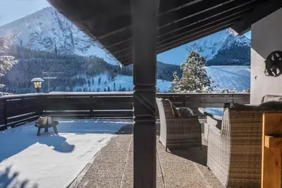 a mountain covered in snow and a cloudy sky at Sirena Carezza Apartments in Carezza al Lago