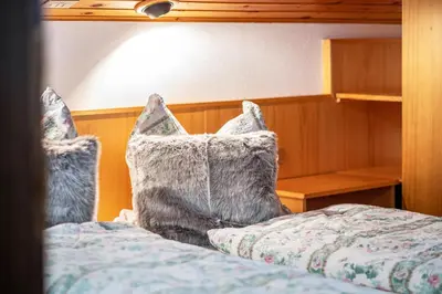 a bedroom with a bed with a blue comforter and pillows at Sirena Carezza Apartments in Carezza al Lago