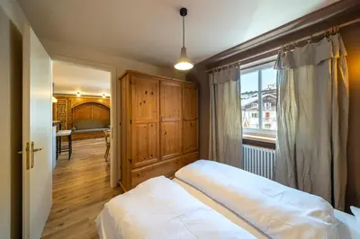 a bedroom with a bed and a large window at Ciasa Buro - Ron in Moena