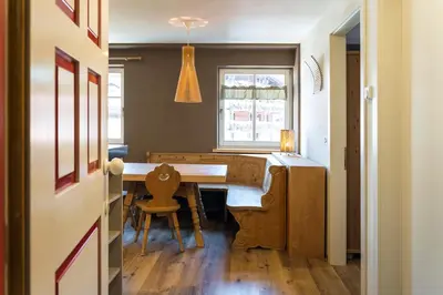 a dining room with a table and a window at Ciasa Buro - Ron in Moena