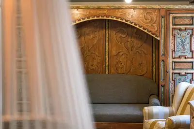 a couch in a room with a wooden wall at Ciasa Buro - Ron in Moena