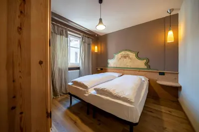 a bedroom with a bed and a window at Ciasa Buro - Ron in Moena