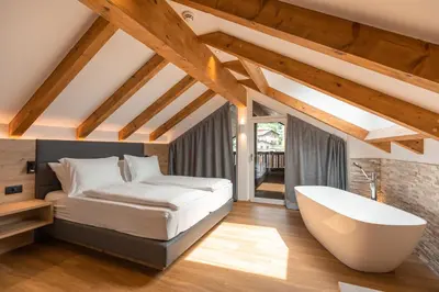 a bedroom with a bed and a bath tub at Am Brunnen Apartments in Naz-Sciaves