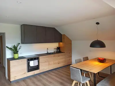 a kitchen with a wooden table and a dining room at Plattenriegelhof in Appiano sulla Strada del Vino