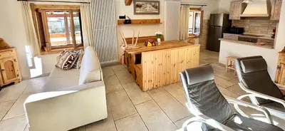 a kitchen with a couch and chairs in a room at Chalet Paradisi in Castello Tesino
