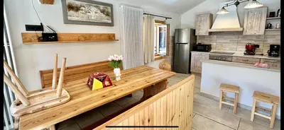 a kitchen with a wooden table and two chairs at Chalet Paradisi in Castello Tesino