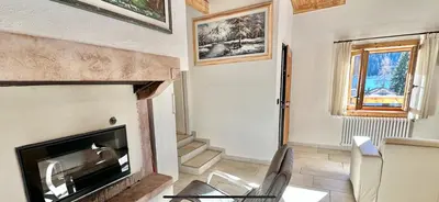 a living room with a fireplace and a television at Chalet Paradisi in Castello Tesino