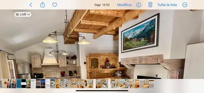 a kitchen with wooden cabinets and a fireplace at Chalet Paradisi in Castello Tesino