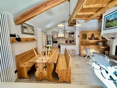 a dining room with a wooden table and chairs at Chalet Paradisi in Castello Tesino