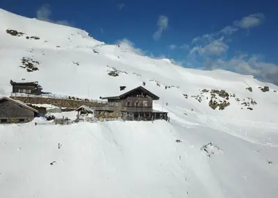 a building on top of a snow covered mountain at Almgasthaus Flecknerhütte in San Leonardo in Passiria
