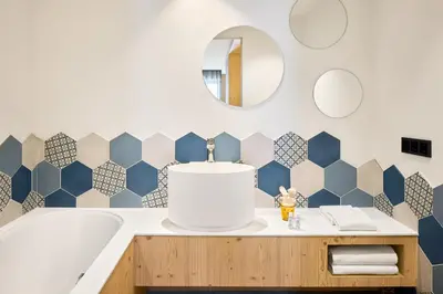 a bathroom with blue and white tile on the wall at Movi Family Apart-Hotel ****s in Corvara in Badia