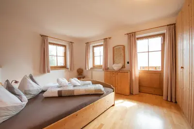 a bedroom with a bed in a room with windows at Ferienwohnungen Kalchgruberhof in Ultimo