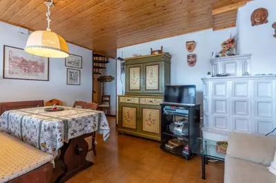 a living room with a table and a tv at Dimora al Vajolet in Pozza di Fassa