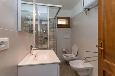 a white bathroom with a sink and a toilet at Dimora al Vajolet in Pozza di Fassa