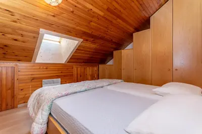 a bedroom with a bed in a wooden cabin at Dimora al Vajolet in Pozza di Fassa