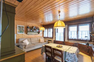 a living room with a couch and a table at Dimora al Vajolet in Pozza di Fassa