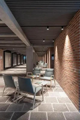 a room with chairs and tables and a brick wall at Cusanus Akademie - Accademia Cusanus in Bressanone