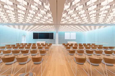 an empty lecture hall with chairs and a flat screen tv at Cusanus Akademie - Accademia Cusanus in Bressanone