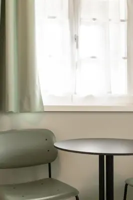 a table and a chair in front of a window at Cusanus Akademie - Accademia Cusanus in Bressanone