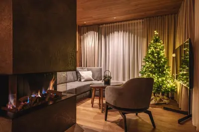 a living room with a christmas tree and a fireplace at Residence Chalet L'Salvan in Selva di Val Gardena