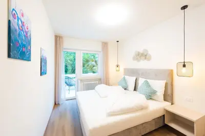 a white couch in a room with a window at Meranosuites - Therme in Merano