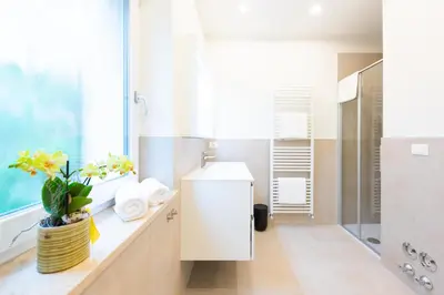 a bathroom with a sink and a shower at Meranosuites - Therme in Merano