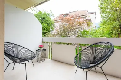 two chairs on the balcony of a apartment at CityPointApartments-Park in Merano