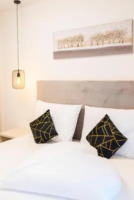 a bedroom with a white bed with black and white pillows at CityPointApartments-Park in Merano